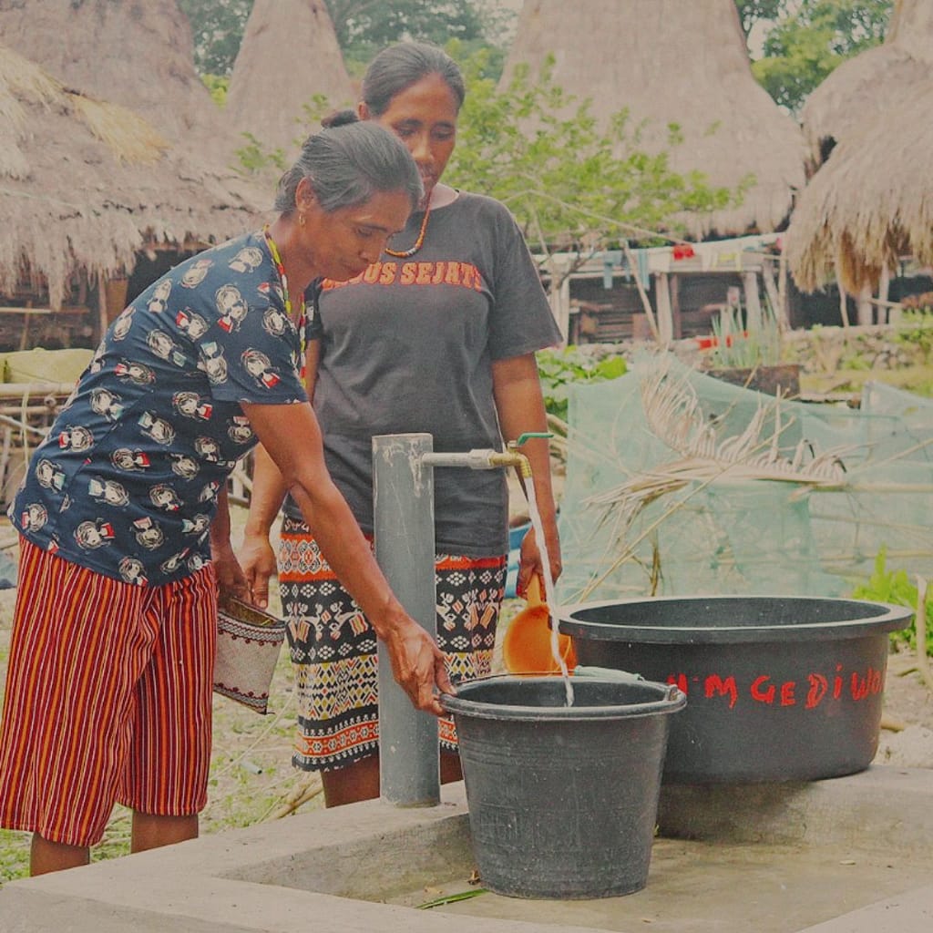 Dos mujeres locales recolectando agua en la isla de Sumba, Indonesia